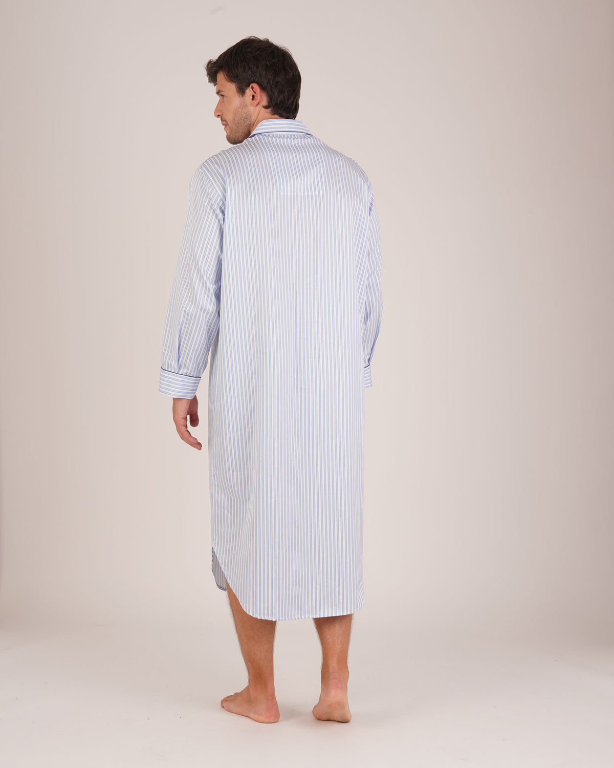 Bonsoir of London Men’s Charles Blue White Stripe Two-Fold Cotton Nightshirt, featuring a blue and white striped design, four-button placket, shirt-tail hem and generously cut fit, full body shot on a model from the back.