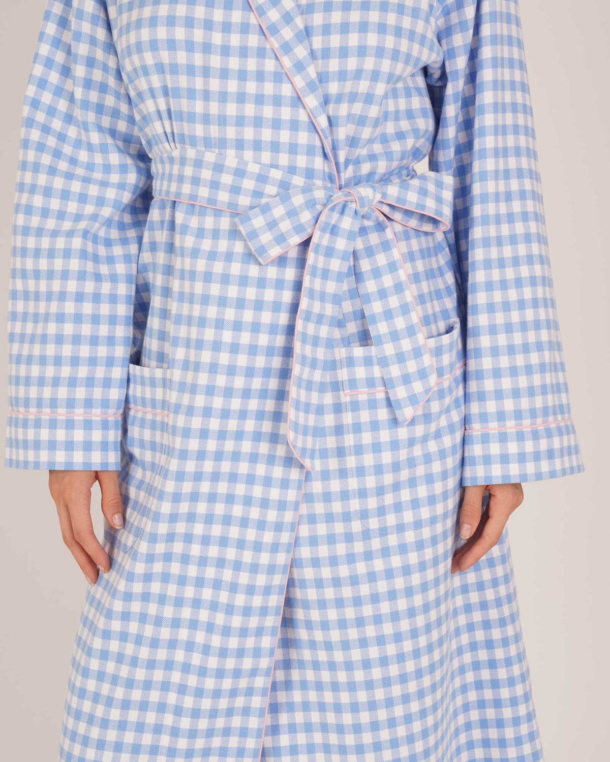 Bonsoir of London Women’s Poppy Blue White Gingham Brushed Cotton Dressing Gown, featuring a blue and white gingham check design, pink piping detail, shot on a model close up.