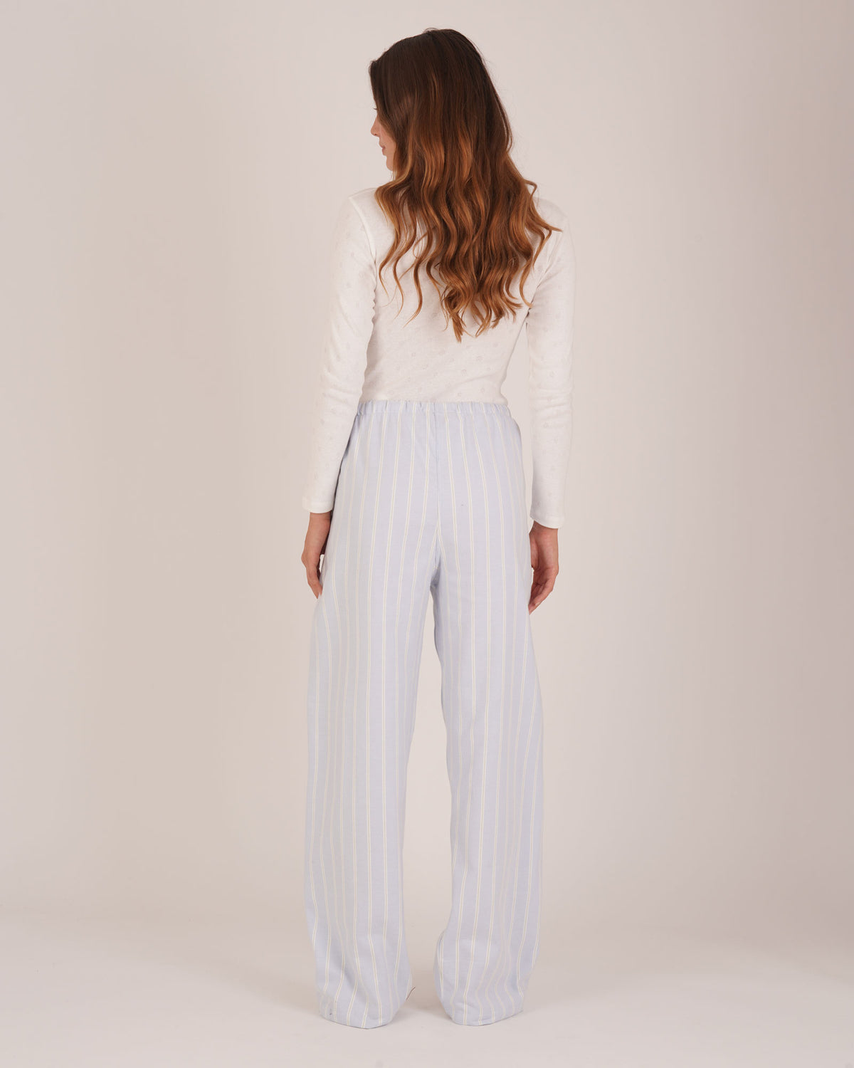 Bonsoir of London Women’s Isla Blue White Stripe Brushed Cotton Pyjama Trousers, featuring a blue and white striped design, relaxed fit, half-elastic and half-drawstring waist, full body shot on a model from the back