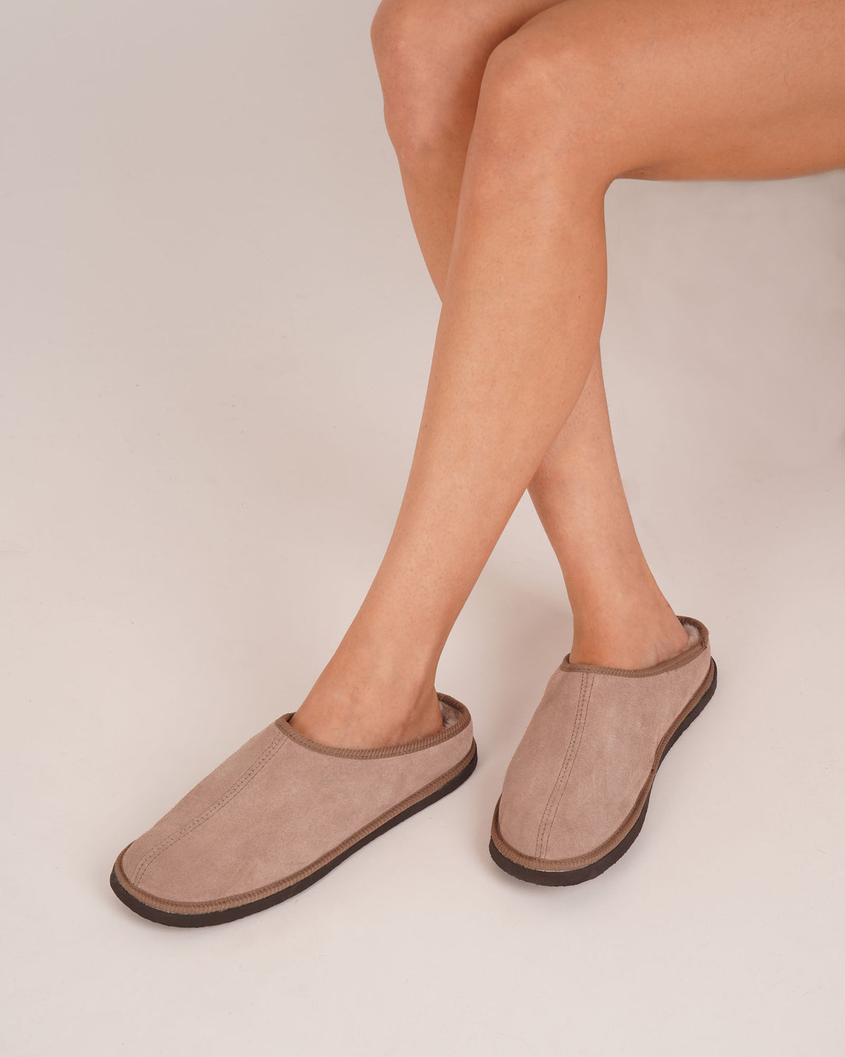 Bonsoir of London Women’s Beatrice Sheepskin Mule Slippers in Nut, crafted from soft suede with natural sheepskin lining, slip-on mule design, rubber sole, shot on a model.