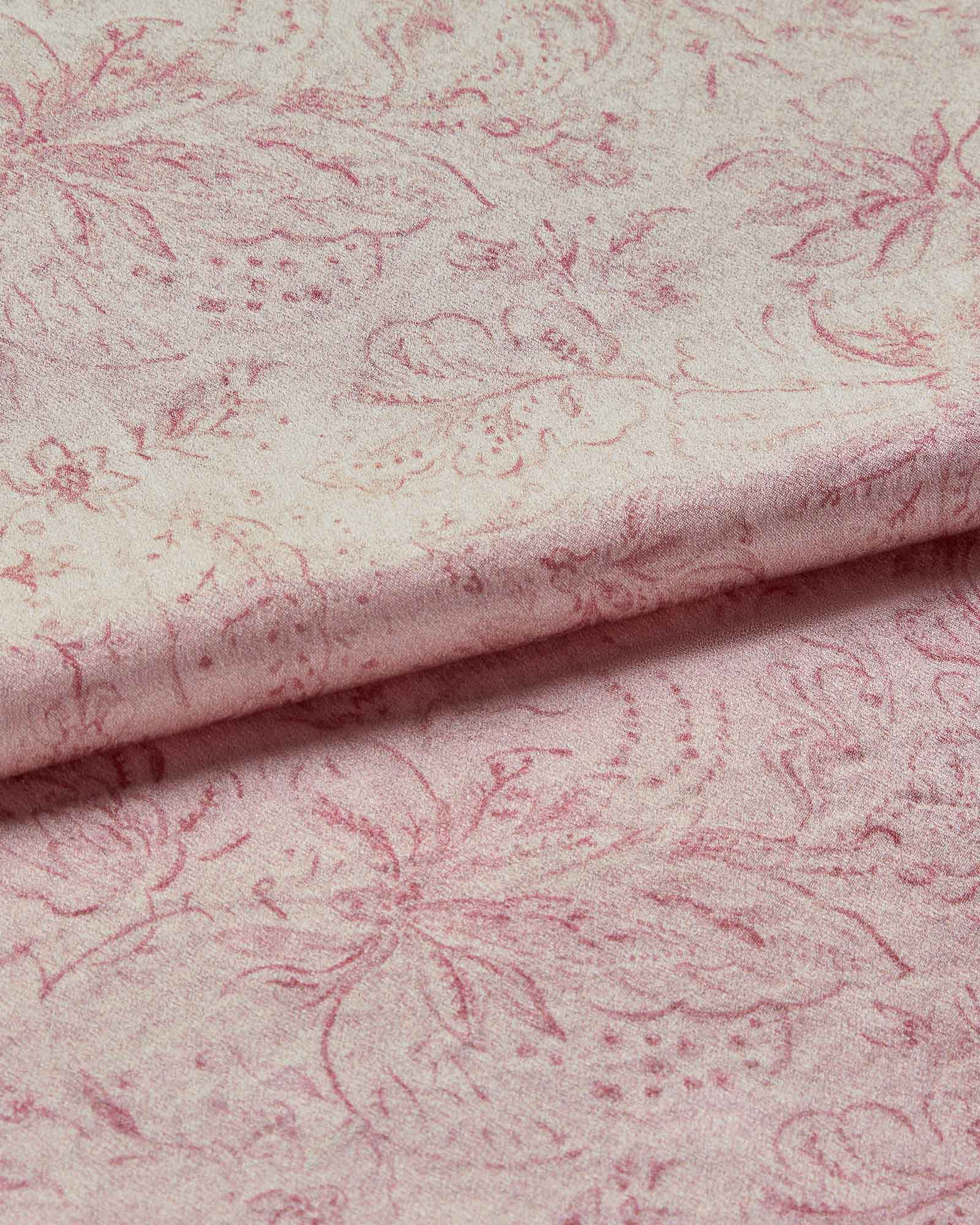 A folded piece of silk fabric with a floral print design in pink on a white background.
