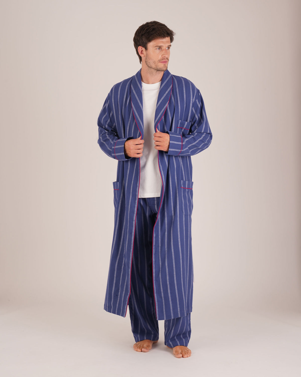 Bonsoir of London Men’s Alexander Navy White Stripe Brushed Cotton Dressing Gown, featuring 100% brushed cotton, a navy and white striped design, shawl collar, wide tie belt, patch pockets, full body shot on a model.