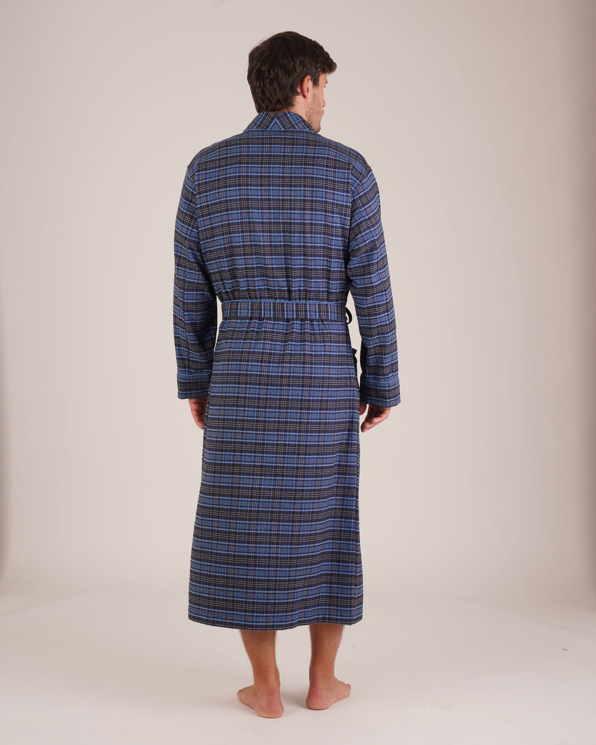 Bonsoir of London Men’s Theodore Blue Plaid Brushed Cotton Dressing Gown, featuring a blue and navy plaid design with subtle gold detailing, shawl collar, wide tie belt, patch pockets, full body shot on a model from the back.