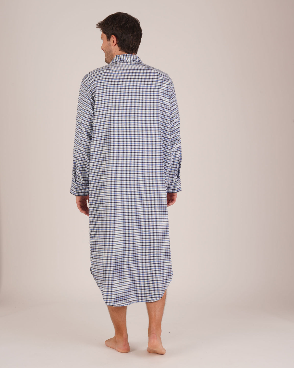 Bonsoir of London Men’s Arthur Blue Check Brushed Cotton Nightshirt, featuring a blue, white and navy check design, four-button placket, shirt-tail hem and generously cut fit, full body shot on a model from the back.