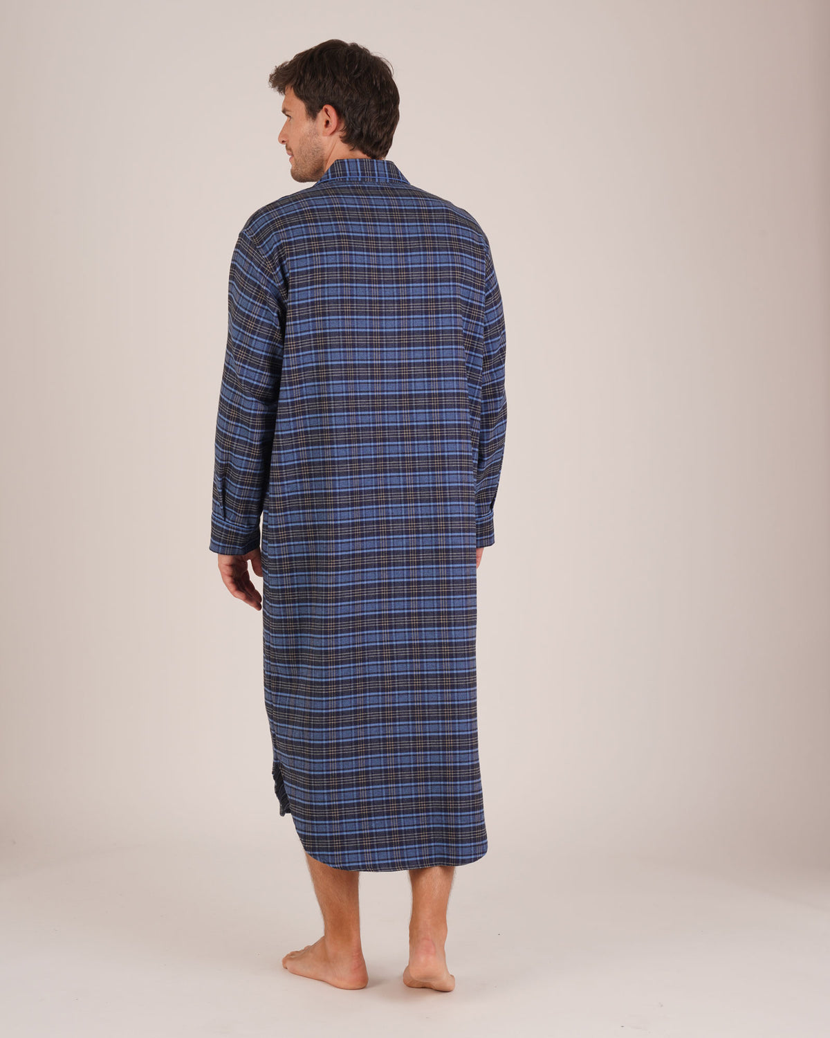 Bonsoir of London Men’s Theodore Blue Plaid Brushed Cotton Nightshirt, featuring a blue and navy plaid design with subtle gold detailing, four-button placket, shirt-tail hem and generously cut fit, full body shot on a model from the back.