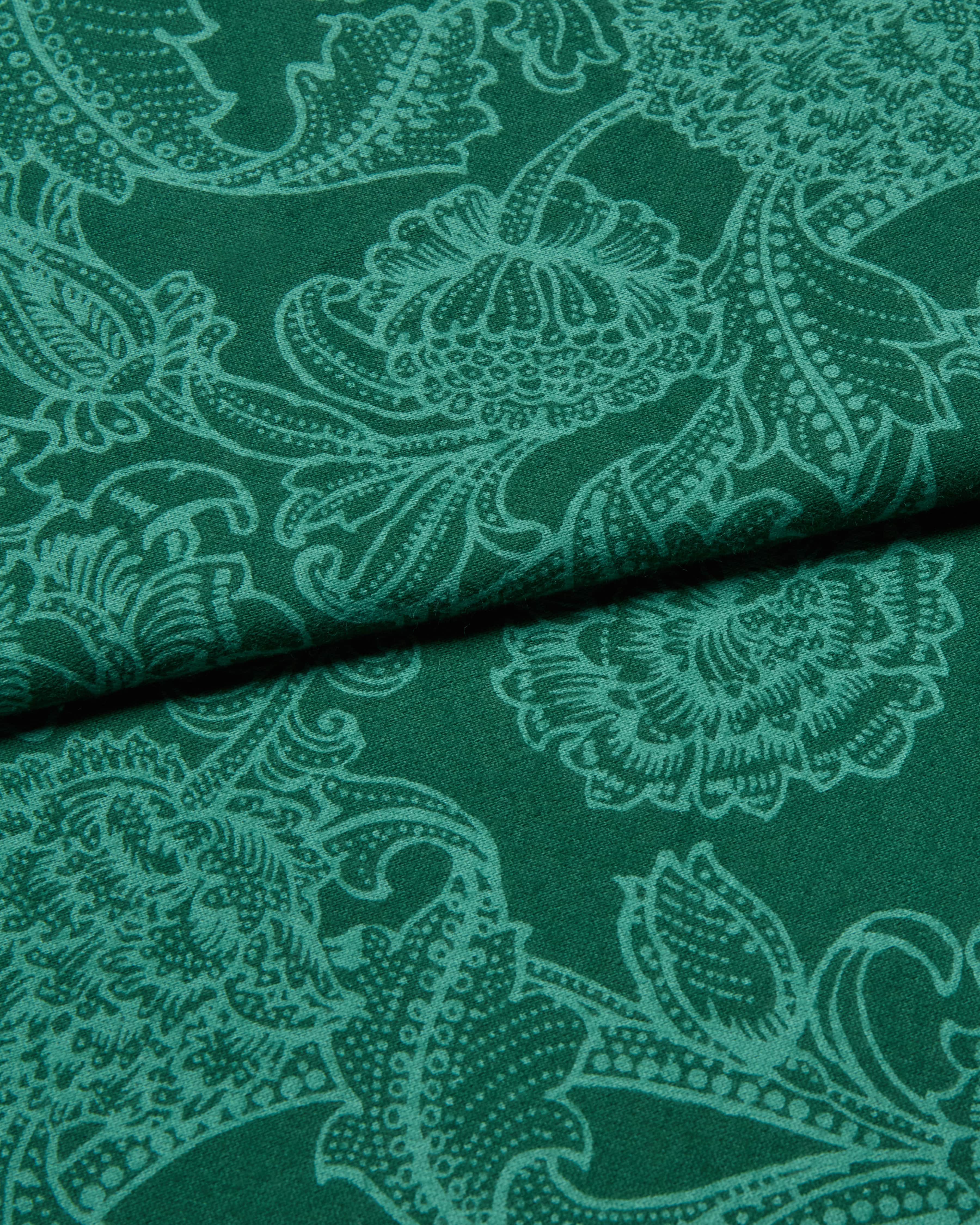 Green fabric with intricate white floral paisley pattern