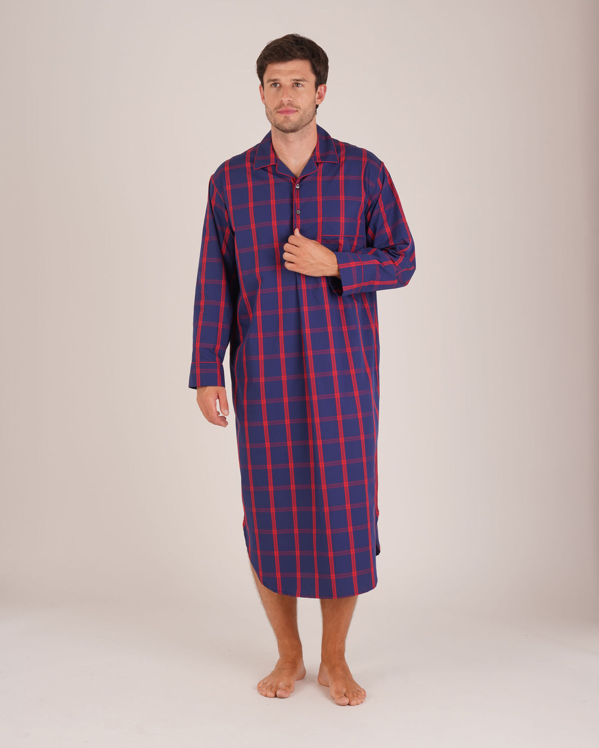 Bonsoir of London Men’s James Blue Red Tartan Classic Cotton Nightshirt, featuring a navy blue and red tartan check design, four-button placket, shirt-tail hem and generously cut fit, full body shot on a model.