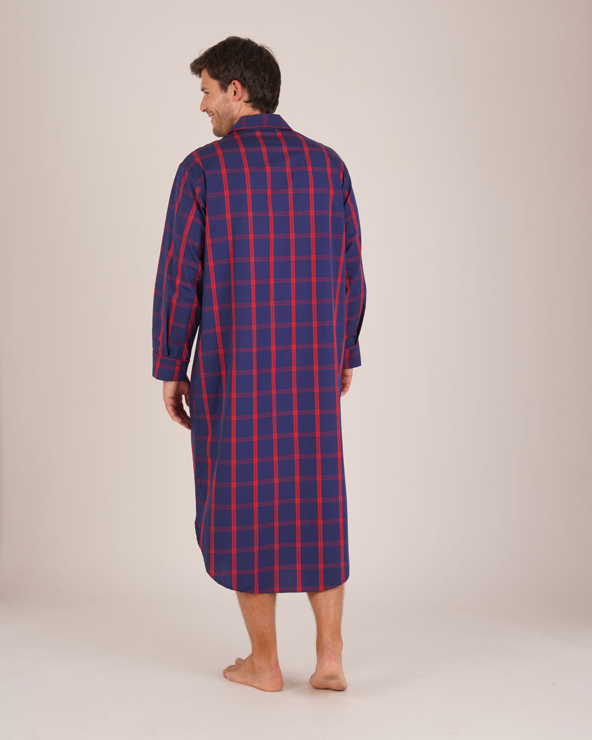 Bonsoir of London Men’s James Blue Red Tartan Classic Cotton Nightshirt, featuring a navy blue and red tartan check design, four-button placket, shirt-tail hem and generously cut fit, full body shot on a model from the back.
