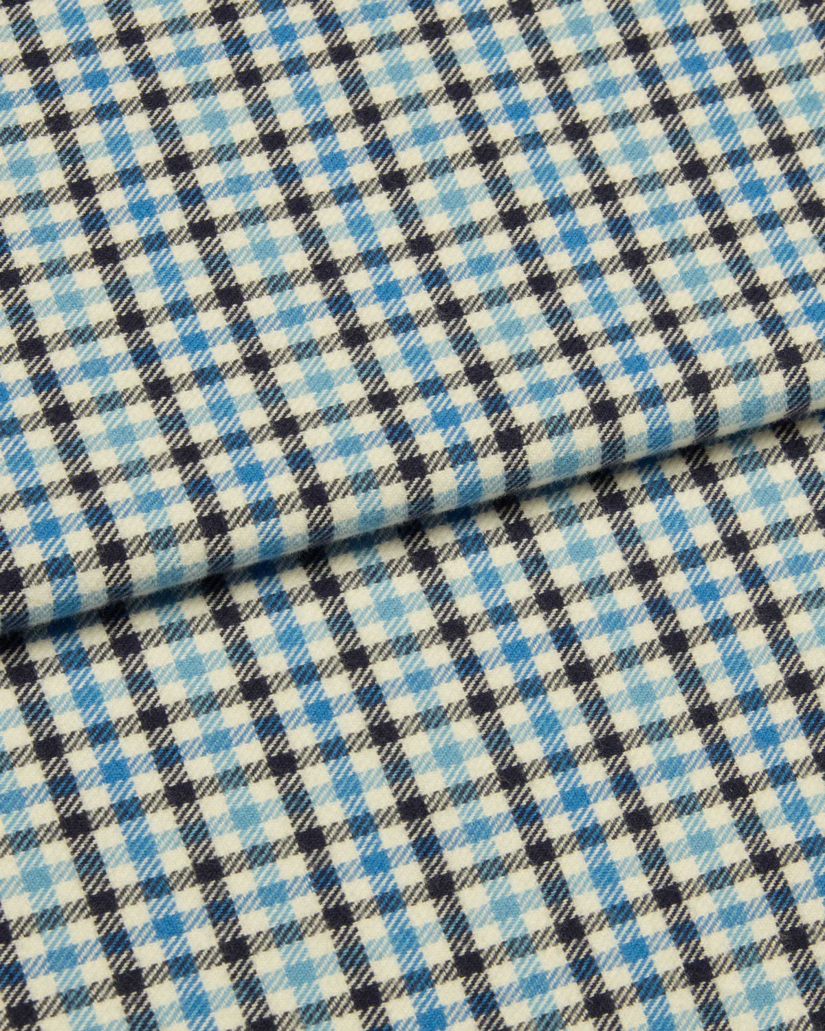 Bonsoir of London brushed cotton fabric, featuring a blue, white and navy check design, close up of the fabric.