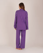 Bonsoir of London Women’s Lily Purple Stripe Brushed Cotton Pyjamas, featuring a purple striped design, square-hemmed jacket, half-elasticated waist with self-fabric tie trouser, complementary piping, full body shot on a model from the back.