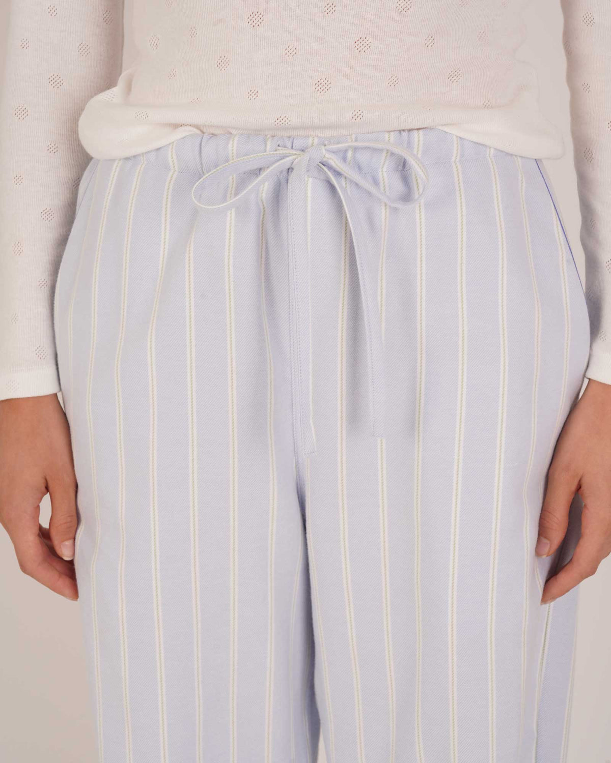 Bonsoir of London Women’s Isla Blue White Stripe Brushed Cotton Pyjama Trousers, featuring a blue and white striped design, relaxed fit, half-elastic and half-drawstring waist, close up shot on a model.