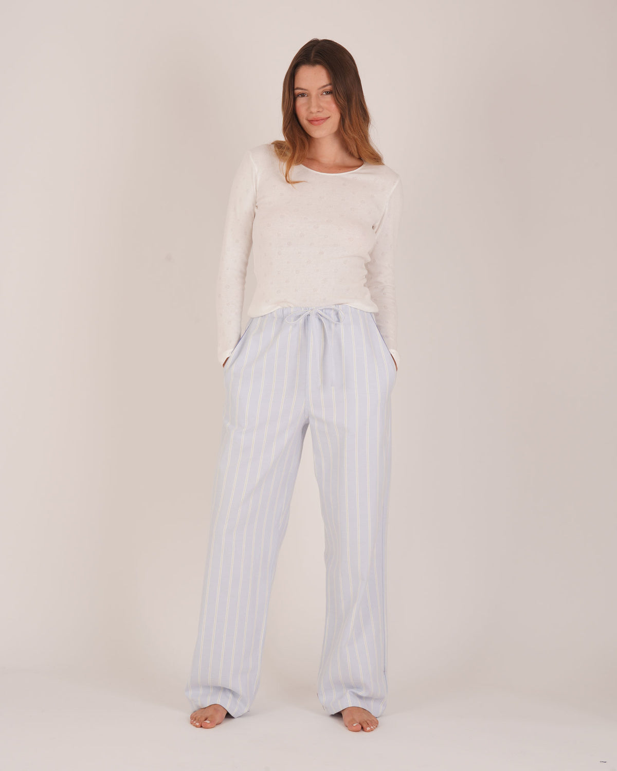 Bonsoir of London Women’s Isla Blue White Stripe Brushed Cotton Pyjama Trousers, featuring a blue and white striped design, relaxed fit, half-elastic and half-drawstring waist, full body shot on a model.