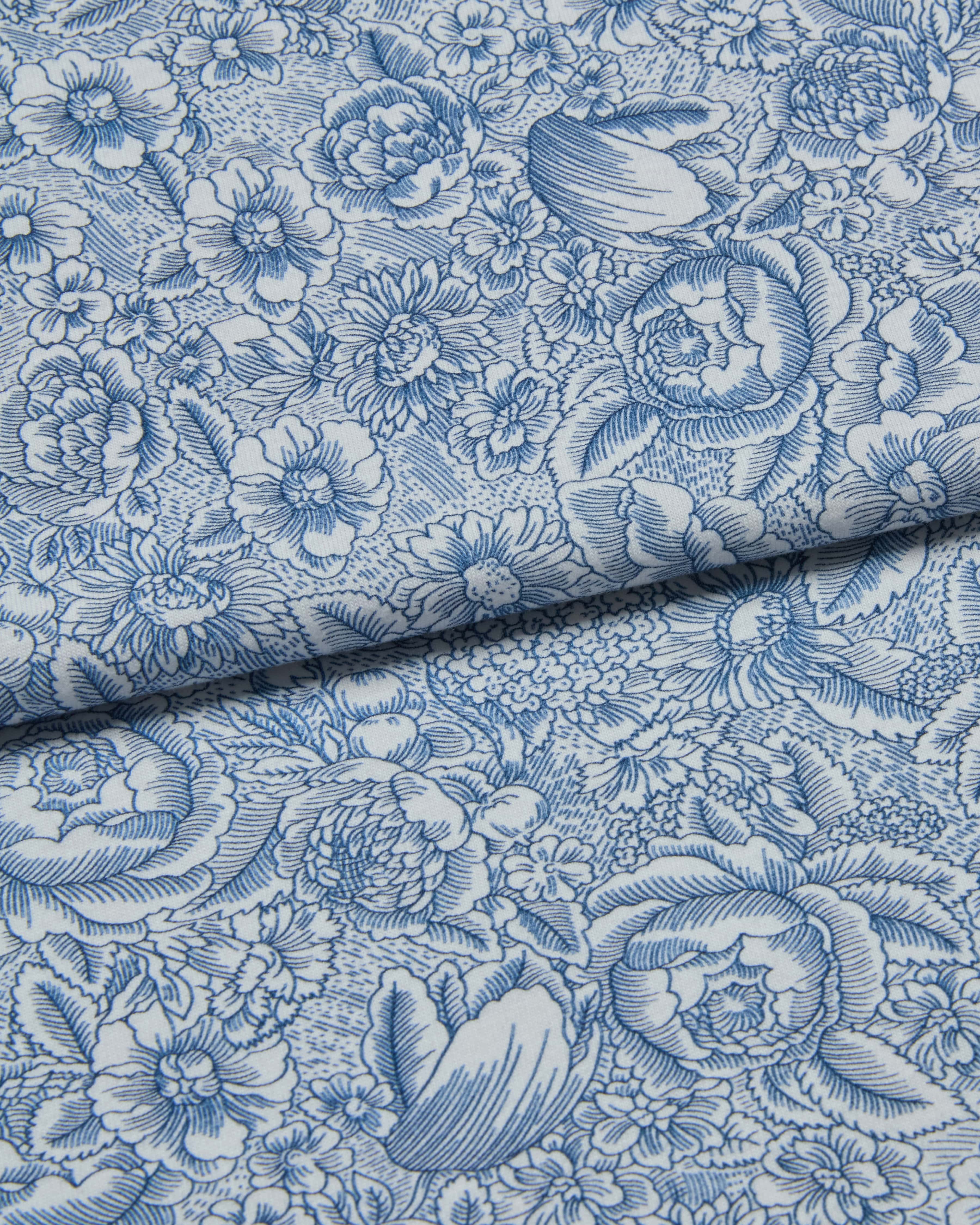 Floral patterned jersey fabric with blue flowers on a white background