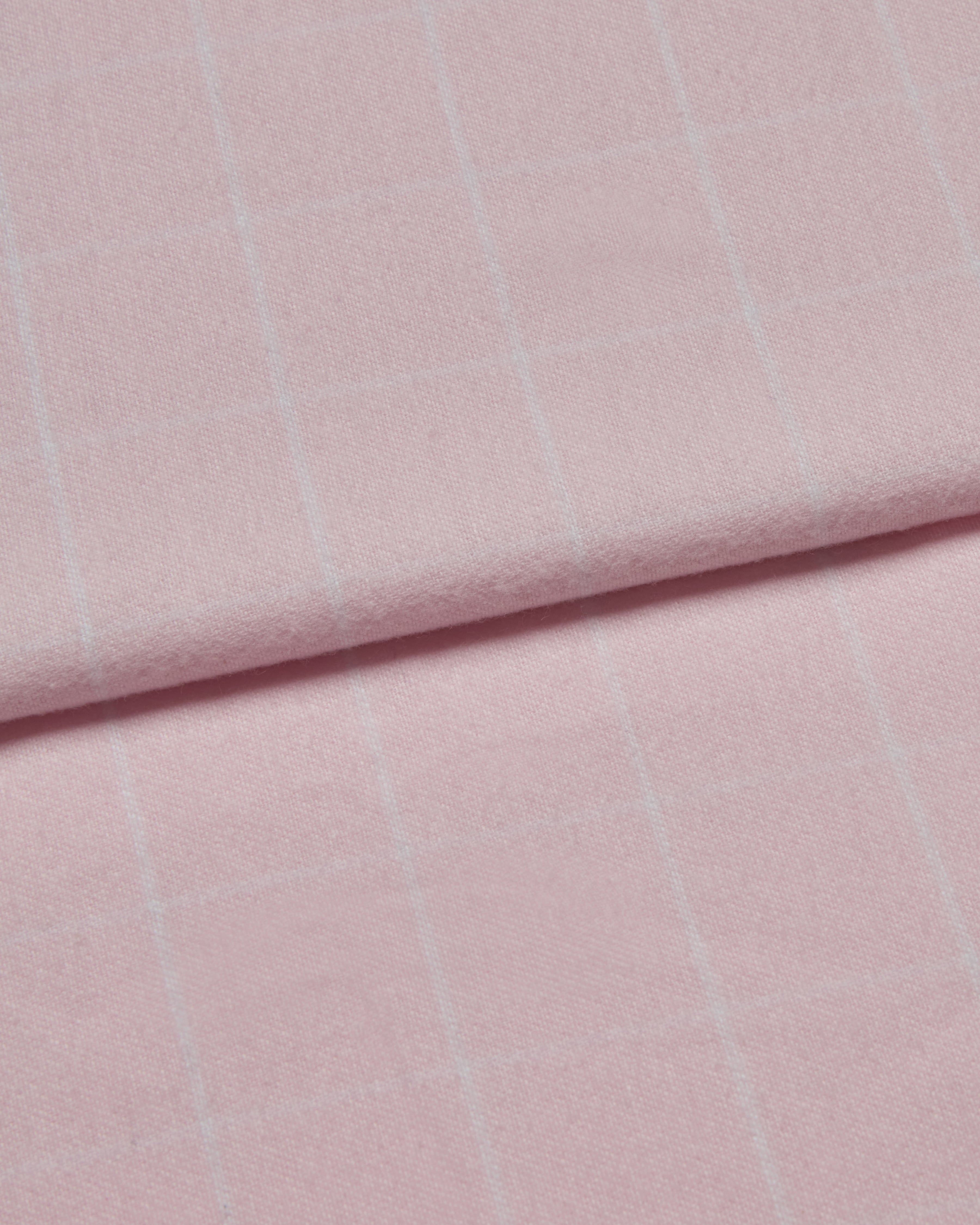 Close-up of pink brushed cotton fabric with subtle white check pattern.