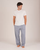 Bonsoir of London Men’s Arthur Blue Check Brushed Cotton Pyjama Trousers, featuring a blue, pale blue, white and navy check design, 100% brushed cotton, fully elasticated waist, concealed button fly, self-fabric drawstring tie and pockets, full body shot on a model.