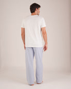 Bonsoir of London Men’s Oliver Blue White Stripe Brushed Cotton Pyjama Trousers, featuring a pale blue and white striped design, 100% brushed cotton, fully elasticated waist, concealed button fly, self-fabric drawstring tie and pockets, full body shot on a model from the back.