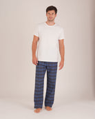 Bonsoir of London Men’s Theodore Blue Plaid Brushed Cotton Pyjama Trousers, featuring a blue and navy plaid design, 100% brushed cotton, fully elasticated waist, concealed button fly, self-fabric drawstring tie and pockets, full body shot on a model.