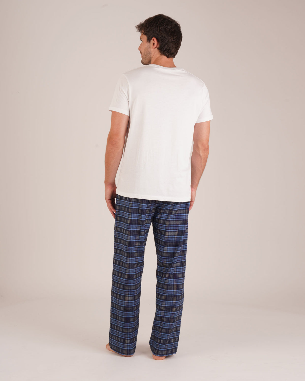 Bonsoir of London Men’s Theodore Blue Plaid Brushed Cotton Pyjama Trousers, featuring a blue and navy plaid design, 100% brushed cotton, fully elasticated waist, concealed button fly, self-fabric drawstring tie and pockets, full body shot on a model from the back.