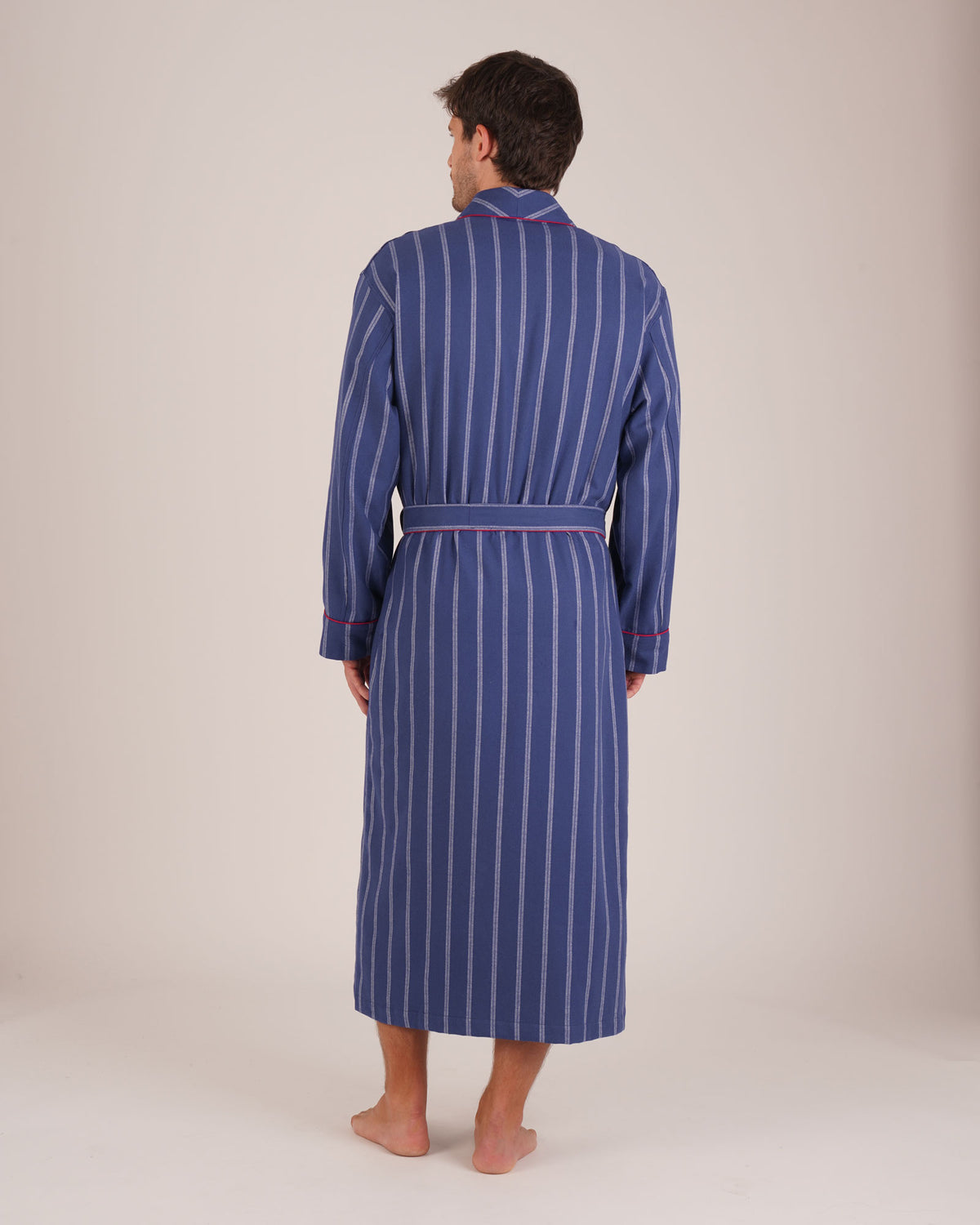 Bonsoir of London Men’s Alexander Navy White Stripe Brushed Cotton Dressing Gown, featuring 100% brushed cotton, a navy and white striped design, shawl collar, wide tie belt and patch pockets, full body shot on a model from the back.