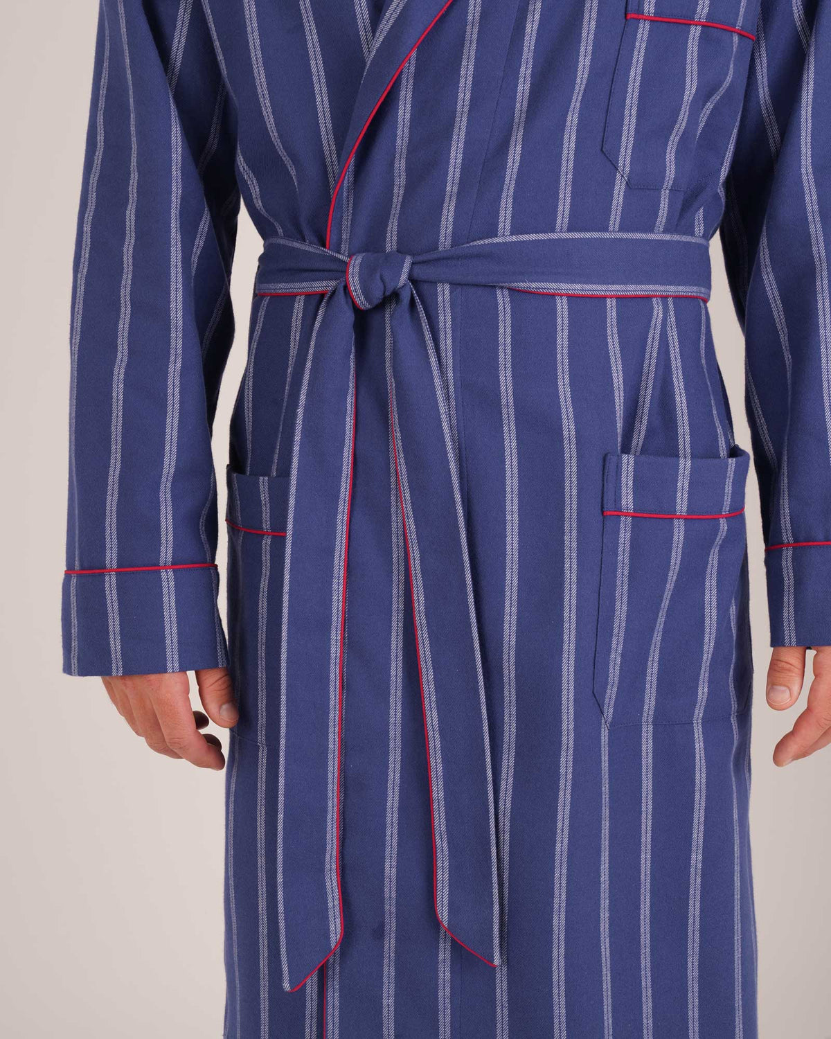Bonsoir of London Men’s Alexander Navy White Stripe Brushed Cotton Dressing Gown, featuring 100% brushed cotton, a navy and white striped design, shawl collar, wide tie belt and patch pockets, close up shot on a model.