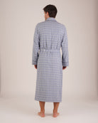 Bonsoir of London Men’s Arthur Blue Check Brushed Cotton Dressing Gown, featuring a soft blue, white and navy check design, shawl collar, wide tie belt, patch pockets, full body shot on a model from the back.