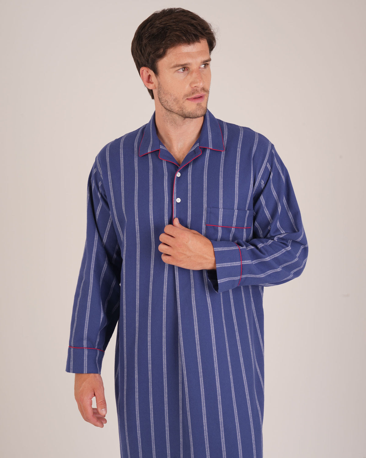 Bonsoir of London Men’s Alexander Navy White Stripe Brushed Cotton Nightshirt, featuring a navy and white striped design, four-button placket, shirt-tail hem and generously cut fit, piping detail, half body shot on a model.
