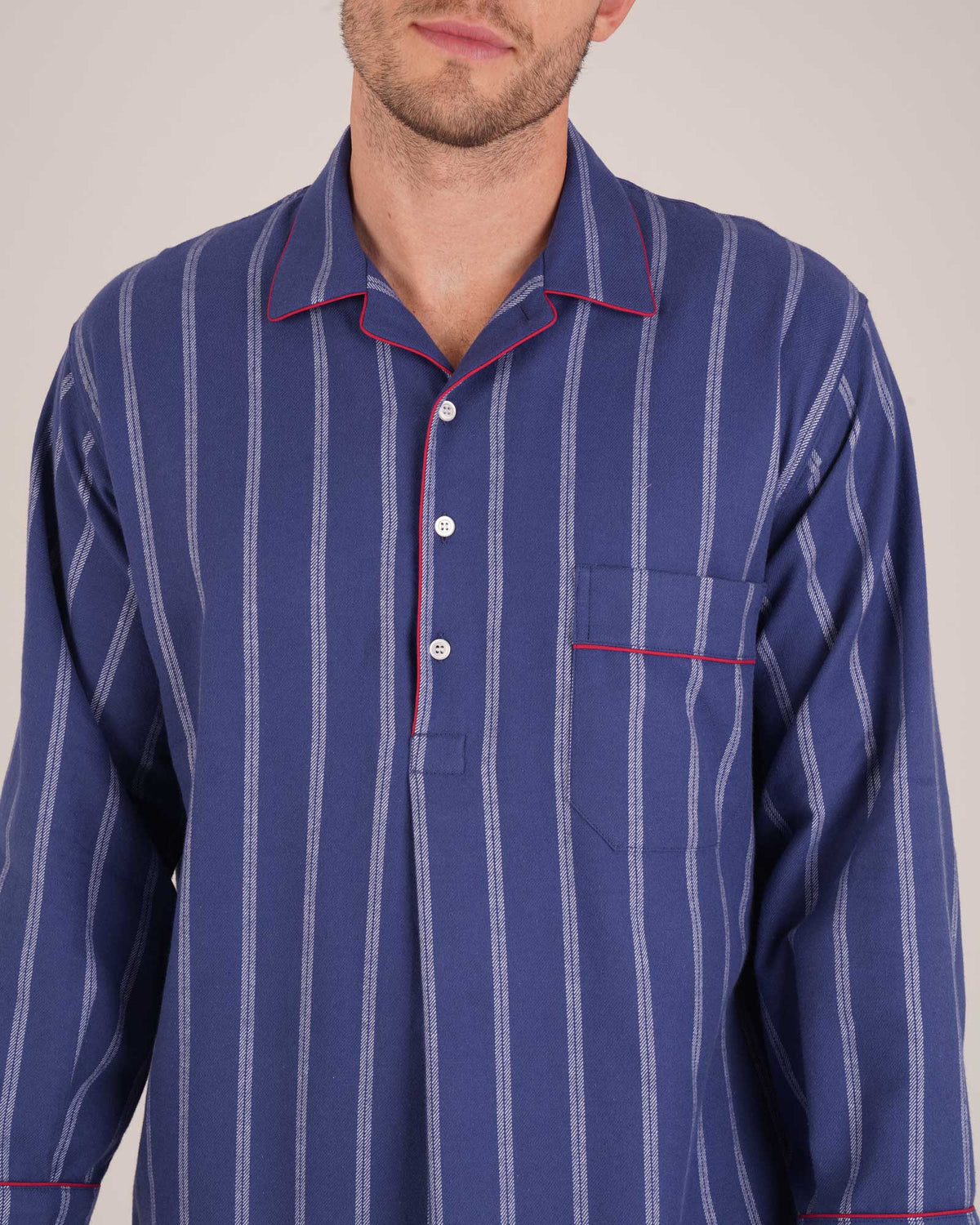 Bonsoir of London Men’s Alexander Navy White Stripe Brushed Cotton Nightshirt, featuring a navy and white striped design, four-button placket, shirt-tail hem and generously cut fit, piping detail, close up shot on a model.