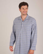 Bonsoir of London Men’s Arthur Blue Check Brushed Cotton Nightshirt, featuring a blue, white and navy check design, four-button placket, shirt-tail hem and generously cut fit, half body shot on a model.