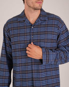 Bonsoir of London Men’s Theodore Blue Plaid Brushed Cotton Nightshirt, featuring a blue and navy plaid design with subtle gold detailing, four-button placket, shirt-tail hem and generously cut fit, close up shot on a model.