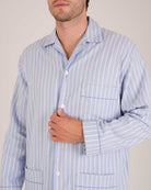 Bonsoir of London Men’s Oliver Blue White Stripe Brushed Cotton Pyjamas, featuring a pale blue and white striped design, three jacket pockets, elasticated-waist trousers, button fastening and concealed button fly, close up shot on a model.
