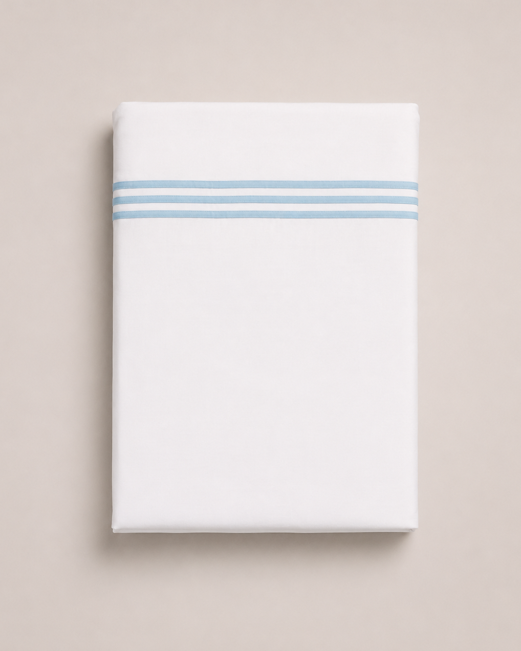 Bonsoir of London white cotton flat sheets with 3 light blue embroidered stripes, folded on a studio background.